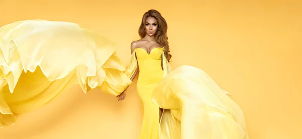 stock image Fashion Woman in Yellow fluttering Dress. Glamour Model dancing with Long Silk Fabric flying on Wind. Elegance.