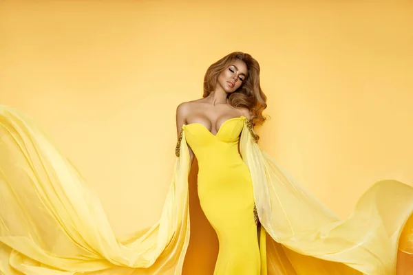 노란색 거리는 드레스입은 글래머 모델은 바람을 나르는 있습니다 — 스톡 사진