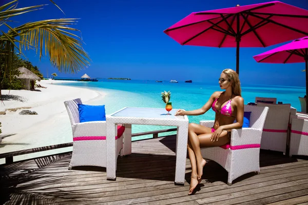 穿着雅致比基尼的漂亮姑娘站在游泳池里 喝着五彩缤纷的果香饮料 身穿亮片比基尼的性感女人正躺在马尔代夫岛上的游泳池里 奢侈的旅行 — 图库照片