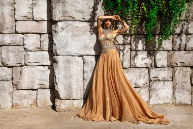 Şık lüks akşam modası. Cazibeli, şık, uzun elbiseli kadın Türkiye 'de lüks bir tatil köyünde poz veriyor. Muhteşem uzun elbiseli kadın model. Vogue. Özel tasarım.