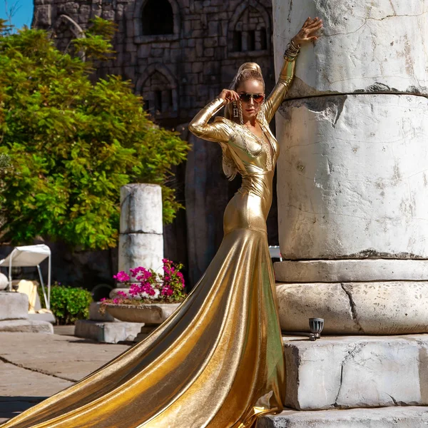 Elegantní Žena Dlouhých Zlatých Večerních Šatech Pózuje Venku Luxusním Resortu — Stock fotografie