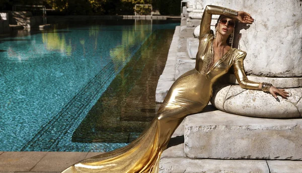 Elegantní Žena Dlouhých Zlatých Večerních Šatech Pózuje Venku Luxusním Resortu — Stock fotografie