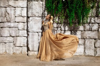 Şık lüks akşam modası. Cazibeli, şık, uzun elbiseli kadın Türkiye 'de lüks bir tatil köyünde poz veriyor. Muhteşem uzun elbiseli kadın model. Vogue. Özel tasarım.