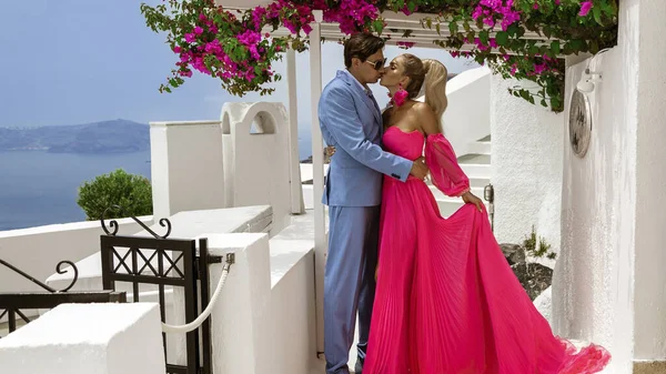 夏の愛 エレガントな結婚式の服の美しい幸せな若いカップルはサントリーニ島のFiraにポーズをとっています ギリシャのサントリーニ島での婚約と結婚式 — ストック写真