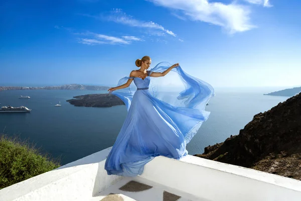 在意大利伊莫洛维里的桑托里尼豪华度假胜地 穿着长袍的迷人而优雅的女人正在斯卡罗斯岩石附近摆姿势 女模特穿着惊人的长裙 — 图库照片