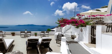 Santorini, Yunanistan. Önünde çiçekler olan küçük bir sokakta deniz ve gökyüzünün inanılmaz manzarası. Konum: Oia Santorini, Yunanistan.