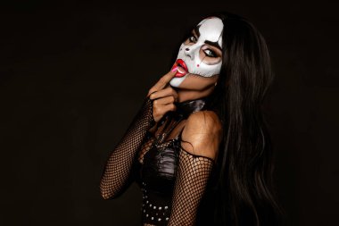 Cadılar Bayramı makyajı ve siyah arka planda kostüm giymiş seksi bir kadın. Cadılar Bayramı makyaj ve kostüm konsepti.