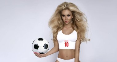 Spor giyimli seksi Polonyalı kız futbol topu tutuyor ve şampiyonada Polonya takımını destekliyor. Polonya temsilciliği