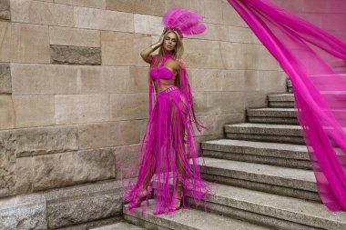 Seksi sarışın tanrıça, uzun bacaklı, seksi pembe makrome elbiseli şehrimizde şehvetle dolaşıyor..