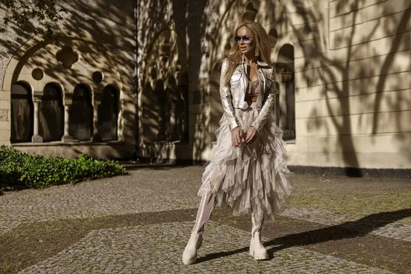 Şık Bej Elbiseli Moda Modeli ve Yaz Güneşi 'nde Şık Motosiklet Ceketi Pozu. Yaz Kentsel Moda.