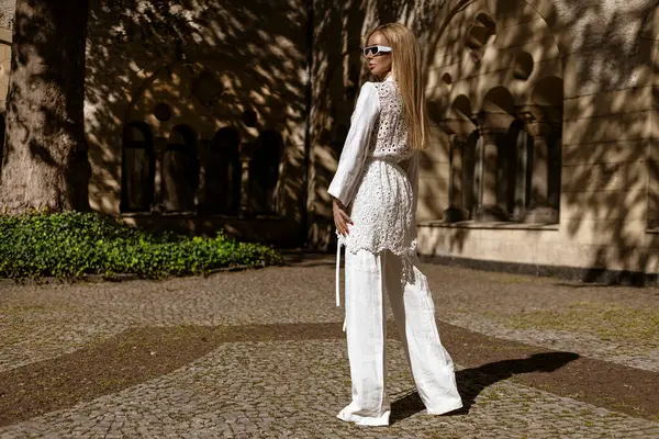 Güneşli bir yaz gününde beyaz, modaya uygun keten kıyafetler giyen zarif bir kadın manken şehrimizde şehvetle dolaşıyor. Zarafet. Yaz modası