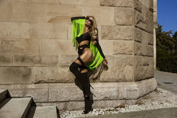 Nefis bronz tenli, şık bikinili ve çizmelerinin üzerindeki siyah tenli seksi sarışın manken güneşli bir yaz gününde şehrimizde şehvetle yürüyor. Açık havada fotoşop.