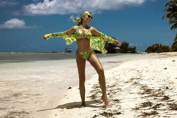 Tropikal yeşil bikinili ve eşarplı seksi manken Seyşeller 'deki güneşli kumlu kumlu sahilde poz veriyor.