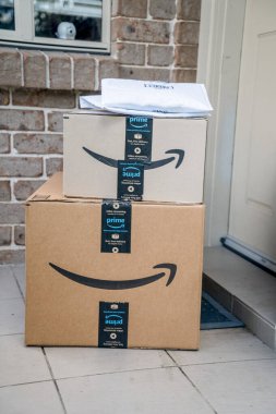 Sydney, Avustralya - 2022-07-22 Amazon ana kutuları ve zarfları bir apartmanın ön kapısına teslim edildi. Kara Cuma Siber Pazartesi Noel Satışı Günü. Amazon Flex teslimatı