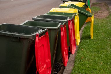 Genel olarak renkli kapaklı Avustralya çöp kutuları ve belediye çöpleri için kaldırım kenarındaki ev atıklarının geri dönüşümü