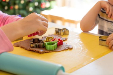 Seçici odaklanma. Çocuklar çeşitli Noel kurabiyeleriyle zencefilli kurabiye yapıyorlar. Zencefilli ekmek hamuru. Aile Noel eğlencesi anları