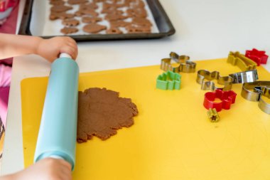 Seçici odaklanma. Çocuklar çeşitli Noel kurabiyeleriyle zencefilli kurabiye yapıyorlar. Zencefilli ekmek hamuru. Aile Noel eğlencesi anları