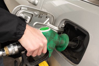 Benzin dolduran bir adam el ele tutuşuyor. Depoya benzin pompalıyorum. Benzin istasyonunda kırmızı bir araba yakıtı.