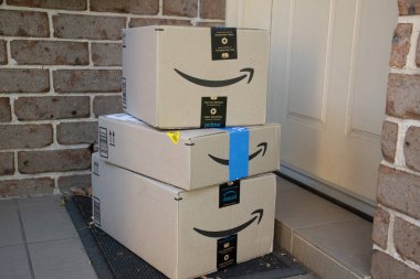 Sydney, Avustralya - 2023-07-12 Amazon ana kutuları ve zarfları bir apartmanın ön kapısına teslim edildi. Kara Cuma Siber Pazartesi Noel Satışı Günü. Amazon Flex teslimatı