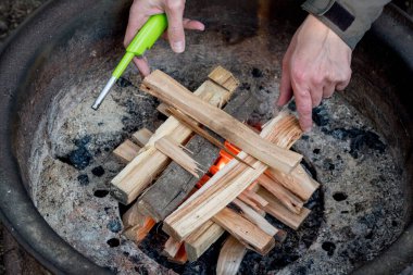 Yakacak odun ateşiyle bir kamp ateşi yakmak. Kamp yaşam tarzı.