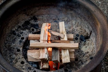 Yakacak odun ateşiyle bir kamp ateşi yakmak. Kamp yaşam tarzı.