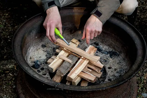 Yakacak odun ateşiyle bir kamp ateşi yakmak. Kamp yaşam tarzı.
