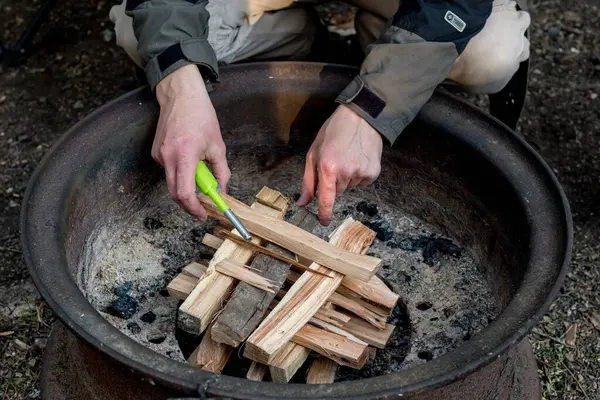 Yakacak odun ateşiyle bir kamp ateşi yakmak. Kamp yaşam tarzı.