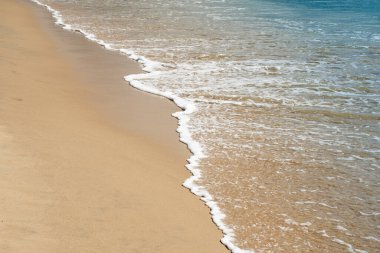 Kumlu bir sahilde yumuşak okyanus dalgaları. Yaz tatili için seyahat yeri