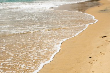 Kumlu bir sahilde yumuşak okyanus dalgaları. Yaz tatili için seyahat yeri