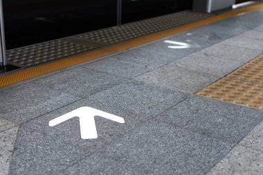 Metro platformu ok işareti tren istasyonunun dokulu zemininde giriş ve çıkışını gösteriyor..