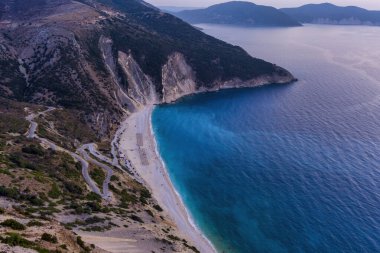 Kefalonia 'daki Myrtos Sahili büyüleyici turkuaz suları, beyaz çakıl taşları ve dik uçurumlarıyla bilinen nefes kesici bir kıyı bölgesi. Bu ikonik plaj yüzmek ve dinlenmek için ideal bir ortam sunuyor.
