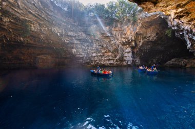 Kefalonia, Yunanistan - 25 Temmuz 2024: Kefalonya 'nın ünlü bir mücevheri olan Melissani Mağarası ve Göl, ziyaretçileri kristal berrak sularını tekneyle keşfetmeleri için ağırlayarak, şaşırtıcı bir ışık etkileşimi ortaya çıkardı.