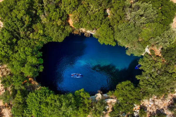Kefalonia 'daki Melissani Mağarası kristal berrak suları olan çarpıcı bir yeraltı mağarası. Güneş ışığı açık tavandan akar, turkuaz gölü aydınlatır ve büyülü bir atmosfer yaratır.