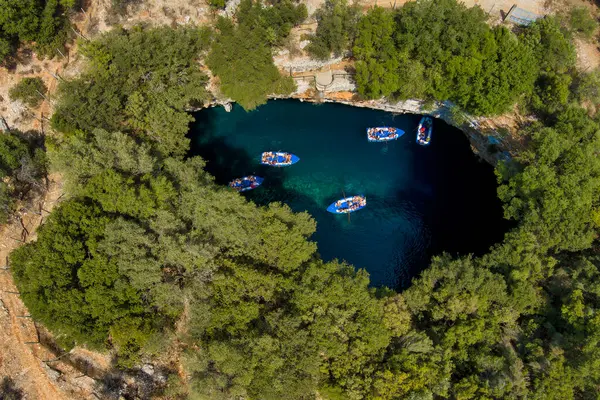 Kefalonia 'daki Melissani Mağarası kristal berrak suları olan çarpıcı bir yeraltı mağarası. Güneş ışığı açık tavandan akar, turkuaz gölü aydınlatır ve büyülü bir atmosfer yaratır.