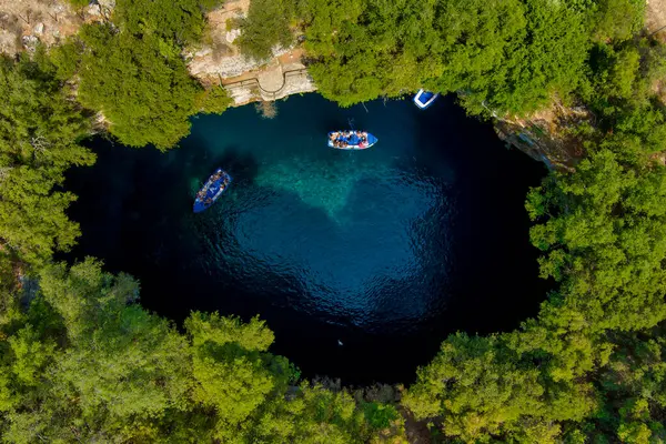 Kefalonia 'daki Melissani Mağarası kristal berrak suları olan çarpıcı bir yeraltı mağarası. Güneş ışığı açık tavandan akar, turkuaz gölü aydınlatır ve büyülü bir atmosfer yaratır.