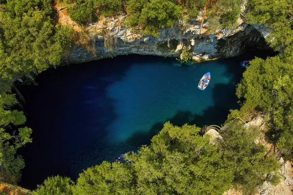 Kefalonia 'daki Melissani Mağarası kristal berrak suları olan çarpıcı bir yeraltı mağarası. Güneş ışığı açık tavandan akar, turkuaz gölü aydınlatır ve büyülü bir atmosfer yaratır.