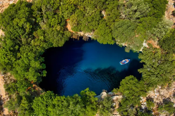 Kefalonia 'daki Melissani Mağarası kristal berrak suları olan çarpıcı bir yeraltı mağarası. Güneş ışığı açık tavandan akar, turkuaz gölü aydınlatır ve büyülü bir atmosfer yaratır.