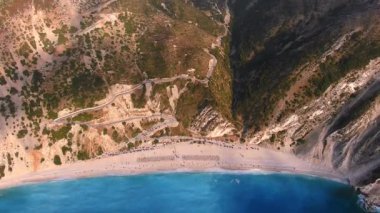 Kefalonia 'daki Myrtos Sahili büyüleyici turkuaz suları, beyaz çakıl taşları ve dik uçurumlarıyla bilinen nefes kesici bir kıyı bölgesi. Bu ikonik plaj yüzmek ve dinlenmek için ideal bir ortam sunuyor.