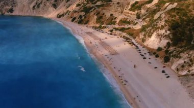 Kefalonia 'daki Myrtos Sahili büyüleyici turkuaz suları, beyaz çakıl taşları ve dik uçurumlarıyla bilinen nefes kesici bir kıyı bölgesi. Bu ikonik plaj yüzmek ve dinlenmek için ideal bir ortam sunuyor.
