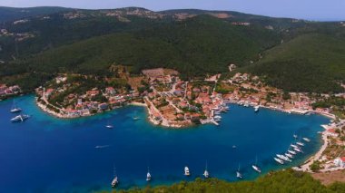 Fiscardo, Kefalonia, Yunanistan. Renkli liman evleri, lüks yatları ve kristal berrak suları olan çarpıcı bir liman köyü. Etrafı yemyeşil tepelerle çevrili, gezginler için çok sevilen bir yer.