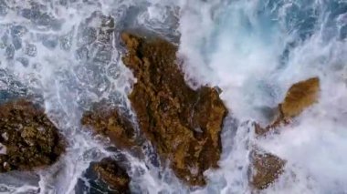 Dalgaların çarptığı derin mavi okyanusun dramatik hava manzarası. Doğal güzelliğin büyüleyici bir görüntüsü