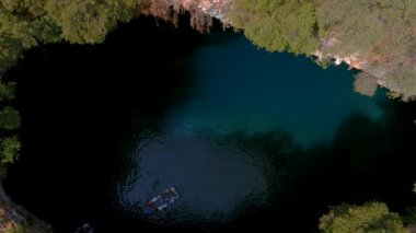 Kefalonia 'daki Melissani Mağarası kristal berrak suları olan çarpıcı bir yeraltı mağarası. Güneş ışığı açık tavandan akar, turkuaz gölü aydınlatır ve büyülü bir atmosfer yaratır.