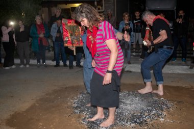 Lagadas, Yunanistan 23 Mayıs 2023: Anastenaria ayini sırasında inananlar, inancın, arındırmanın ve geleneğin sembolü olarak dini simgeler ve kırmızı bezlerle yanan kömürlerin üzerinde yalınayak yürürler.