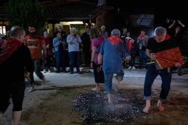 Lagadas, Yunanistan 23 Mayıs 2023: Anastenaria ayini sırasında inananlar, inancın, arındırmanın ve geleneğin sembolü olarak dini simgeler ve kırmızı bezlerle yanan kömürlerin üzerinde yalınayak yürürler.