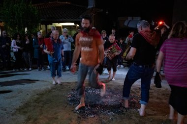 Lagadas, Yunanistan 23 Mayıs 2023: Anastenaria ayini sırasında inananlar, inancın, arındırmanın ve geleneğin sembolü olarak dini simgeler ve kırmızı bezlerle yanan kömürlerin üzerinde yalınayak yürürler.