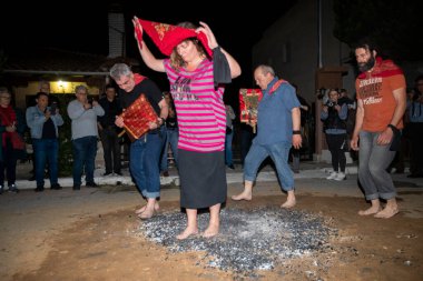 Lagadas, Yunanistan 23 Mayıs 2023: Anastenaria ayini sırasında inananlar, inancın, arındırmanın ve geleneğin sembolü olarak dini simgeler ve kırmızı bezlerle yanan kömürlerin üzerinde yalınayak yürürler.
