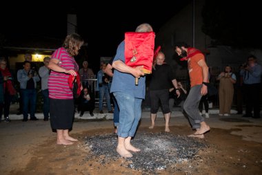 Lagadas, Yunanistan 23 Mayıs 2023: Anastenaria ayini sırasında inananlar, inancın, arındırmanın ve geleneğin sembolü olarak dini simgeler ve kırmızı bezlerle yanan kömürlerin üzerinde yalınayak yürürler.