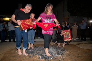 Lagadas, Yunanistan 23 Mayıs 2023: Anastenaria ayini sırasında inananlar, inancın, arındırmanın ve geleneğin sembolü olarak dini simgeler ve kırmızı bezlerle yanan kömürlerin üzerinde yalınayak yürürler.