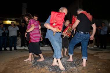Lagadas, Yunanistan 23 Mayıs 2023: Anastenaria ayini sırasında inananlar, inancın, arındırmanın ve geleneğin sembolü olarak dini simgeler ve kırmızı bezlerle yanan kömürlerin üzerinde yalınayak yürürler.