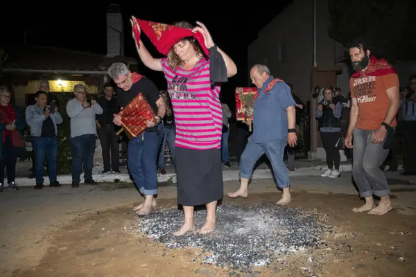 Lagadas, Yunanistan 23 Mayıs 2023: Anastenaria ayini sırasında inananlar, inancın, arındırmanın ve geleneğin sembolü olarak dini simgeler ve kırmızı bezlerle yanan kömürlerin üzerinde yalınayak yürürler.